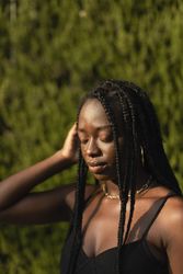 Portrait of a young Black female removing her hair from her face whit her eyes closed