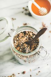 Glass container of homemade granola, with honey