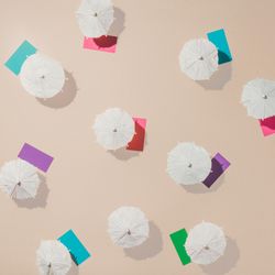 Aerial view of sun umbrellas and multicolored towels on sand