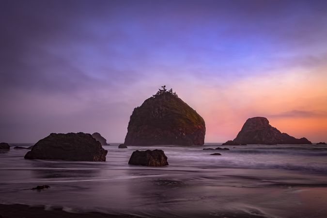 Rocks sitting out from the coast at sunset