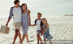 Happy family of four walking on the beach beGB35