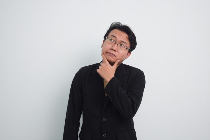 Thoughtful Asian businessman with curious face