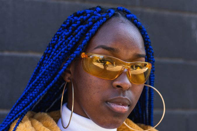 Stylish Black woman in yellow coat in city