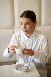 Woman in modern cafe sipping coffee