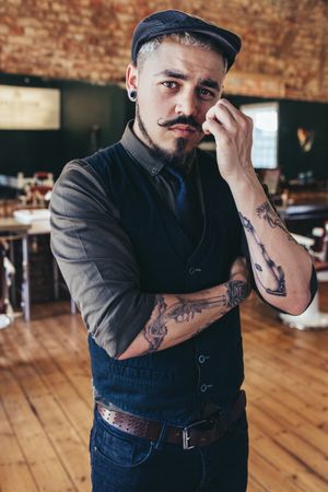 Stylish young male barber looking at camera