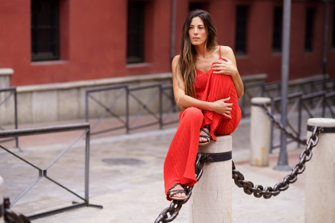 A Stylish Woman Posing Gracefully in an Urban Setting, Showcasing a Bold Red Outfit