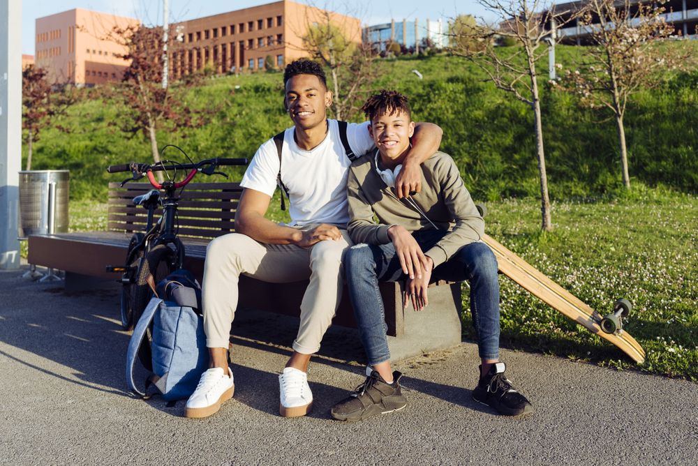 Young Black men playing on street bench