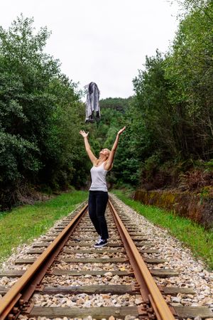 Woman walking along railway though greenery part of road