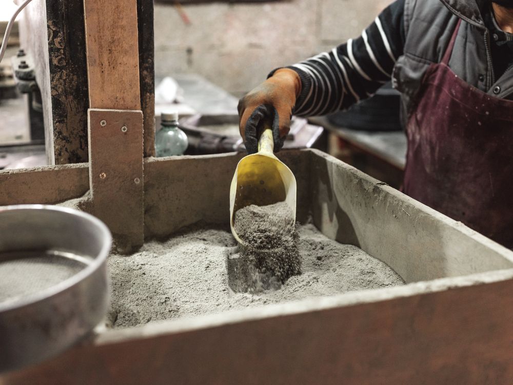 Unrecognizable worker scooping dry material
