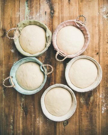 Top view of multiple baskets of bread dough