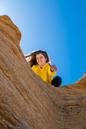 Young female lending helping hand in mountains