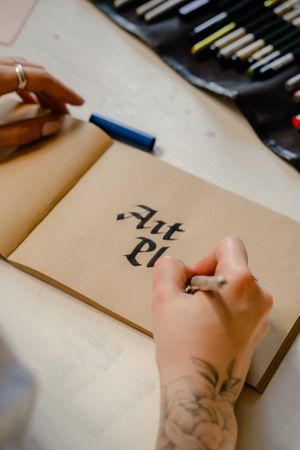 Cropped image of person writing "Art Pi" with calligraphic style