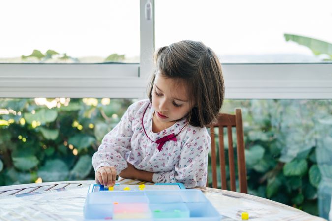 Girl playing with mosaic board game