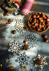 Flour on kitchen counter with Christmas cookies, ingredients and snow flakes