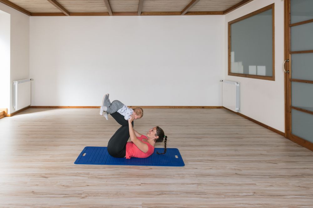Mother exercising with baby in gym