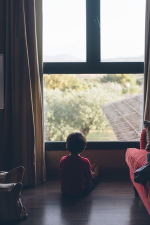 Little boy looking away in window