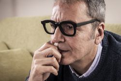 Close-up of an anxious mature man biting his nails.