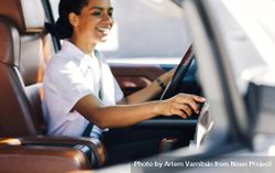 Side view of female smiling and holding a steering wheel 5lkWN0