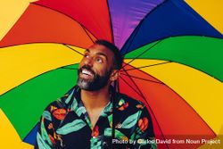 Smiling man looking up from under colorful umbrella 4dNGd0
