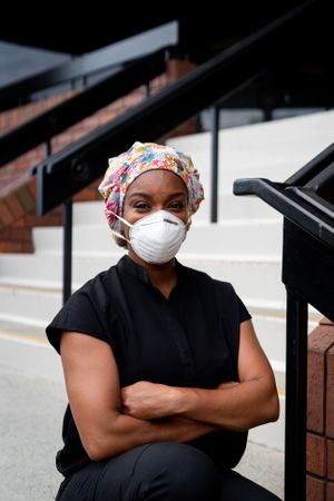 Portrait of nurse in PPE outside of medical office with arms folded