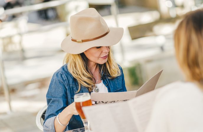 Woman sitting outside cafe drinking beer