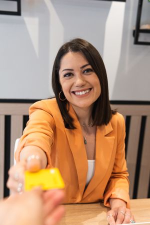 Woman paying for order with plastic card in cafe