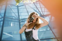 Creative woman taking photo on camera in sunny day