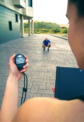 Coach timing man as he breaks between work outs