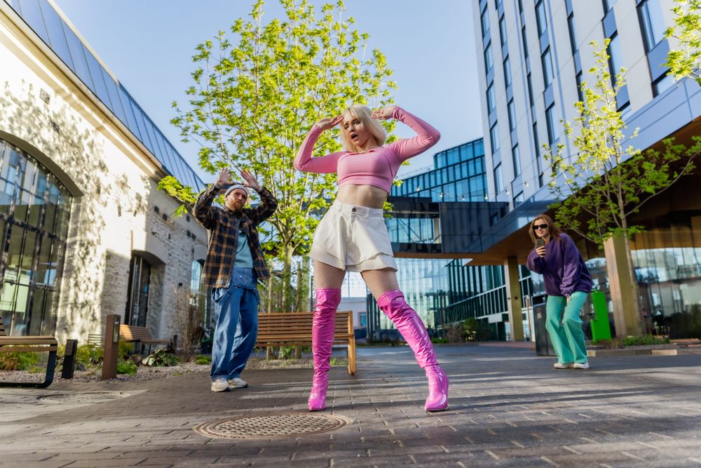 Vibrant Outdoor Scene Capturing Young Adults Joyfully Dancing In An Urban Setting
