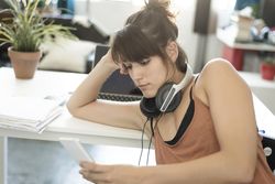Bored woman checking phone at home office