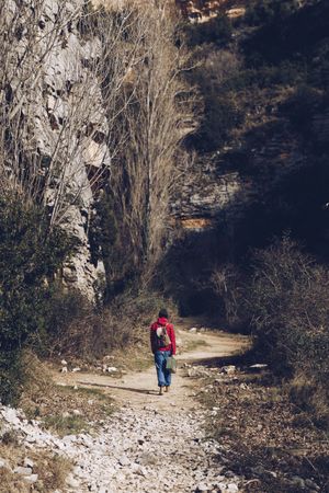 Traveling woman on road in rocky cliffs