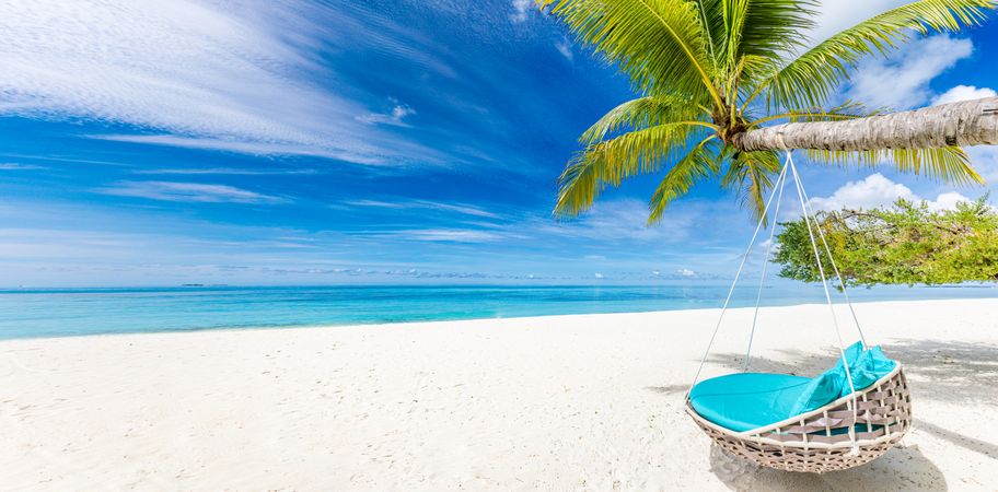 Hanging lounge chair on a tropical beach, wide