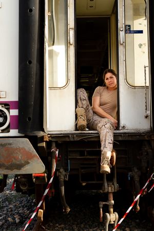 Military woman sitting near van