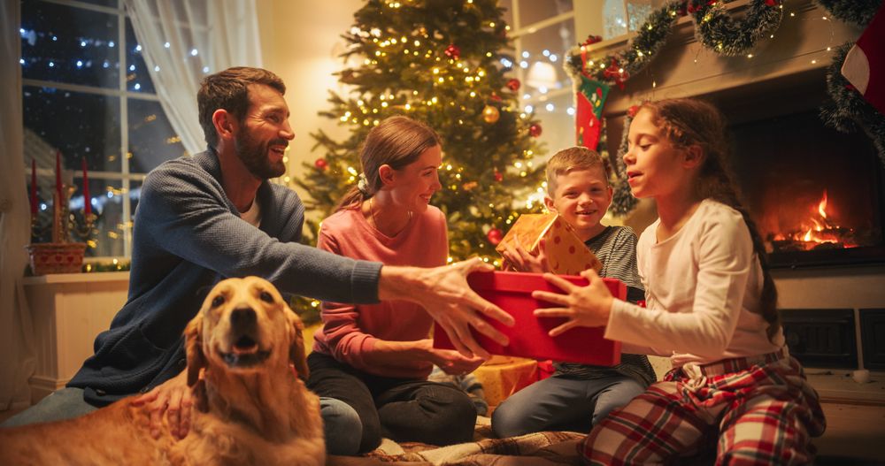 Loving Young Parents Giving Gifts to Their Children on Christmas Eve.