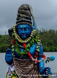 Blue Shiva statue on cloudy day by the lake 4N3Xlb
