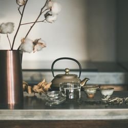 Traditional Japanese tea set, on kitchen counter, with dried cotton, square crop