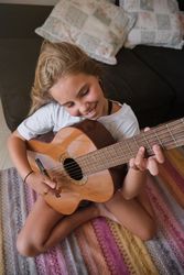 Happy cheerful girl playing acoustic guitar