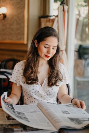 Woman reading a newspaper in a cafe
