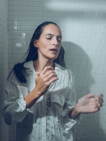 Sensual Hispanic woman in wet shirt taking shower