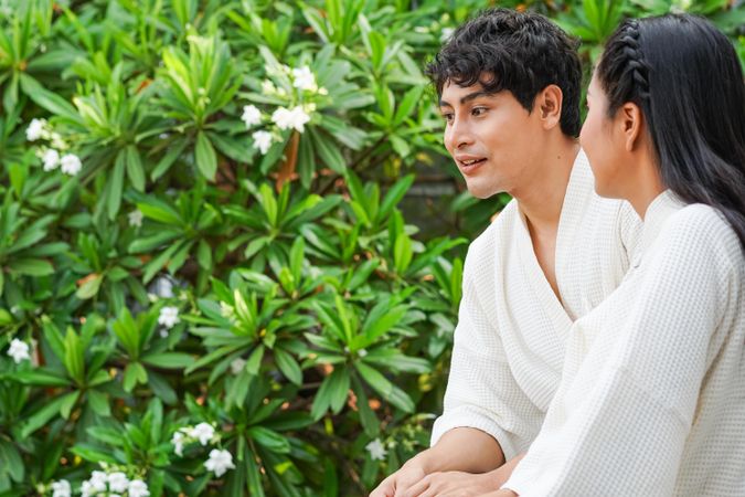 Asian couple in hotel bathrobe standing together at balcony