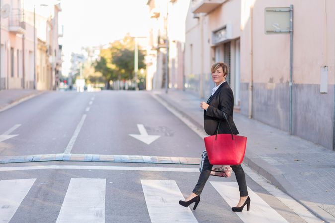 Confident businesswoman crossing the road