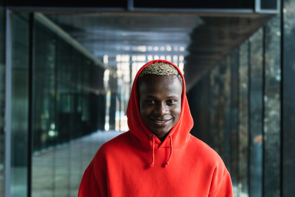 Smiling young Black guy looking at camera in contemporary building