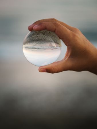 Girl playing with glass ball on seaside
