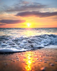 Sunrise macro photography of ocean waves crashing on shore