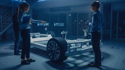 Automobile Engineers Working on Electric Car Platform Chassis, Using Tablet Computers with CAD Software