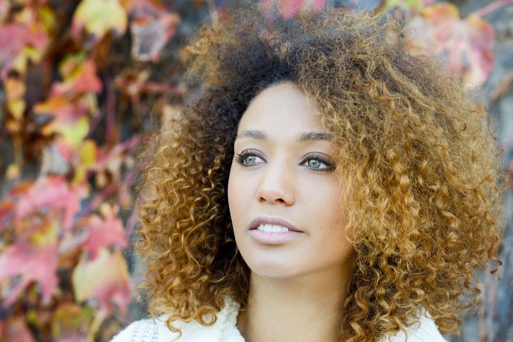 Portrait of wistful woman with fall leaves in background