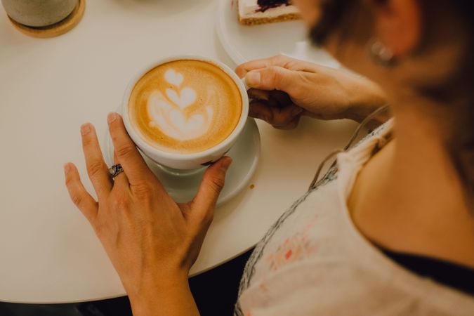 Anonymous woman drinking coffee in cafe