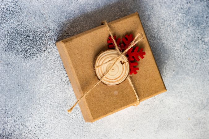 Top view of simple Christmas present with string and snow flake decorations