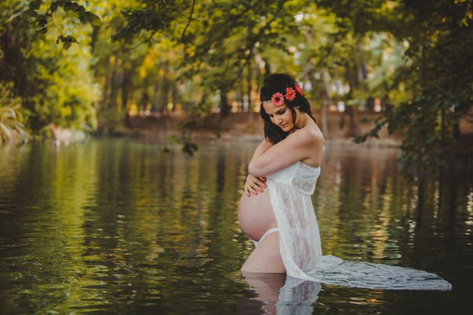 Pregnant woman standing in lake water