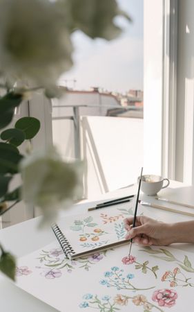 Person drawing flowers with watercolor